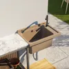 An outdoor sink with a faucet mounted on a wall, next to a marble countertop and tiled flooring. Anteprima dell’immagine prodotto