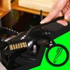 A hand is using a brush attachment on a gas stove. Podgląd zdjęcia produktu