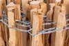 A close-up view of a wooden fence made of thin, pointed wooden stakes bound together with twisted wire. Produktbild-Vorschau