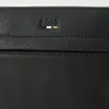 A close-up view of a black leather bag with a BOSS logo. Voir les images du produit