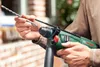 A person is holding a Bosch hammer drill and a drill bit. Produktbild-Vorschau