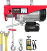 A red electric hoist with accessories, including straps, hooks, and a remote control, displayed against a white background. Náhled obrázku produktu