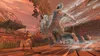 A person in a yellow shirt is fighting against ghostly figures in a dusty, outdoor environment. Produktbild-Vorschau