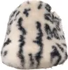 A close-up view of a fuzzy slipper with a black and white animal print pattern. Produktbild-Vorschau