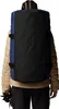 A person wearing a tan puffer jacket and black pants, with a blue and black duffel bag backpack on their back. Voir les images du produit