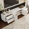 A white TV stand with open drawers and doors, displaying storage compartments and some decorative items, set in a living room with a rug and a TV above. Produktbild-Vorschau