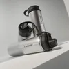 Three silver stainless steel water bottles are arranged on a light gray surface with diagonal lighting. Produktbild-Vorschau