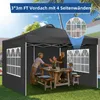 A family enjoying a meal under a black pop-up gazebo in a backyard setting. Voir les images du produit