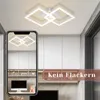 A modern LED ceiling light fixture is shown in a room with white cabinets and a desk with a computer. A smartphone displays a reflection of the ceiling light. Produktbild-Vorschau