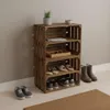A wooden crate shelf unit filled with shoes and accessories, placed against a wall with shoes on the floor. Náhled obrázku produktu