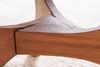A close-up view of the wooden base of a table, showing the joinery and wood grain. Produktbild-Vorschau