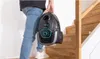 A person is carrying a vacuum cleaner up a wooden staircase. Produktbild-Vorschau