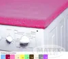 A pink cover is placed on top of a white washing machine. Náhled obrázku produktu