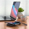 A desk setup with a laptop, a wireless charging power bank with a phone and smartwatch on it, a plant, and a coffee mug. Produktbild-Vorschau