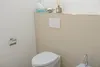 A bathroom scene showing a toilet and a flush plate. Náhľad obrázku produktu