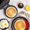 A breakfast scene with waffles, eggs, raspberries, and syrup. Podgląd zdjęcia produktu