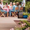 A group of people enjoying an outdoor gathering around a table with food and drinks. Voir les images du produit