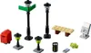 A collection of LEGO street accessories, including lampposts, a mailbox, a bench, a trash can, a phone, and a camera. Voir les images du produit