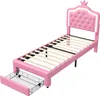 A pink twin bed frame with a tufted headboard and a pull-out drawer. Voir les images du produit
