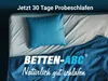 A bed with a blue pillow and blue duvet, with marketing text overlay. Produktbild-Vorschau