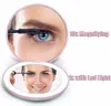 A split image showing a compact makeup mirror with two different views. The top view is a close-up of an eye with mascara being applied, labeled '10x Magnifying'. The bottom view shows a woman applying mascara to her eye in the mirror, which is illuminated Produktbild-Vorschau