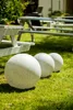 Three large spherical garden ornaments are placed on a grassy lawn in front of white picnic tables. Náhľad obrázku produktu