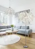 A modern living room with a sectional sofa, coffee tables, and two decorative lamps. Produktbild-Vorschau