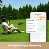 A man relaxing on a chair in a garden while controlling a robot lawn mower with his phone. Produktbild-Vorschau
