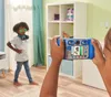 A child is taking a picture of another child with a toy camera in a room. Podgląd zdjęcia produktu