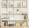 A white bookshelf filled with books and decorative items. Produktbild-Vorschau