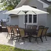 An outdoor patio scene with a dining set and umbrella. Produktbild-Vorschau