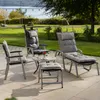 Outdoor patio furniture set with chairs and a table, set on a paved patio with a garden and water in the background. Produktbild-Vorschau