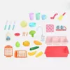 A collection of toy kitchen accessories, including a sink, dishes, and food items, arranged on a white background. Náhled obrázku produktu