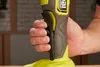 A hand is holding the handle of a power tool. Produktbild-Vorschau