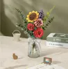 A 3D wooden flower bouquet in a glass vase, with decorative items on a table. Náhľad obrázku produktu