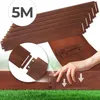 A hand is shown connecting two pieces of wooden garden edging. The product is laid out on green grass. Podgląd zdjęcia produktu