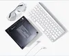 A flat lay of computer accessories including an external DVD drive, a keyboard, earphones, and glasses. Produktbild-Vorschau