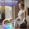 A woman meditating with a cat next to a colorful lamp. Produktbild-Vorschau