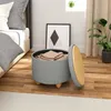 A bedroom scene with a bed, a storage ottoman, and a plant. Produktbild-Vorschau