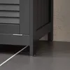 Close-up view of the base of a dark gray cabinet, showing its legs and a small hinge. Náhľad obrázku produktu