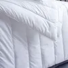 A close-up, detailed view of a white duvet or comforter, showing its quilted texture and stitching. Produktbild-Vorschau