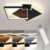 A modern, geometric LED ceiling light fixture with a black and white design, shown illuminated on a white ceiling. Below the main image, there are four smaller images demonstrating different light color temperatures. A white remote control with various but Produktbild-Vorschau