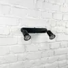 A black double spotlight fixture mounted on a white brick wall. Anteprima dell’immagine prodotto