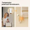 A woman is using her smartphone to control a towel warmer via an app, illustrating remote temperature control. Produktbild-Vorschau