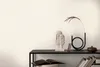 A shelf with decorative items and books against a textured white wall. Produktbild-Vorschau
