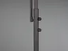 A close-up view of the dark gray metal pole of a floor lamp, showing two black adjustment knobs. Náhled obrázku produktu