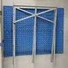 A metal sawhorse is mounted on a blue pegboard wall. Produktbild-Vorschau