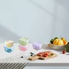 A collection of small, colorful food storage containers are neatly arranged on a white surface, with a cutting board holding sliced meat and vegetables in the foreground, and a bowl of produce in the background. Produktbild-Vorschau
