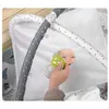 A baby playing on an interactive mat with a mirror and toys. Voir les images du produit