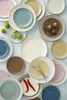 A collection of various colored plates and some limes and figs. Produktbild-Vorschau